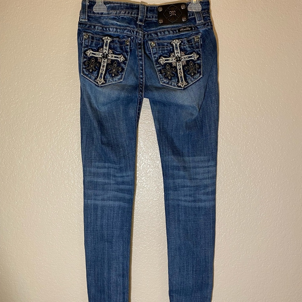 These are country style Miss Me jeans with crosses on back pockets. Dark denim